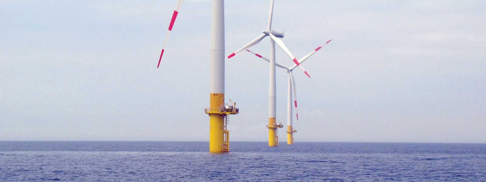 Three windmills at sea